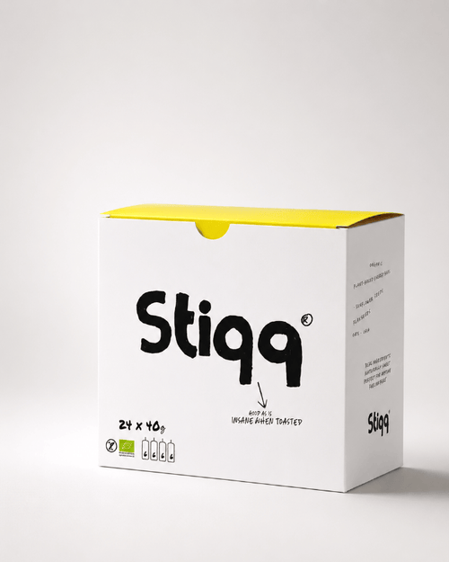 Stiqq gluten free savoury bar product packaging with yellow top and white body on a light gray background